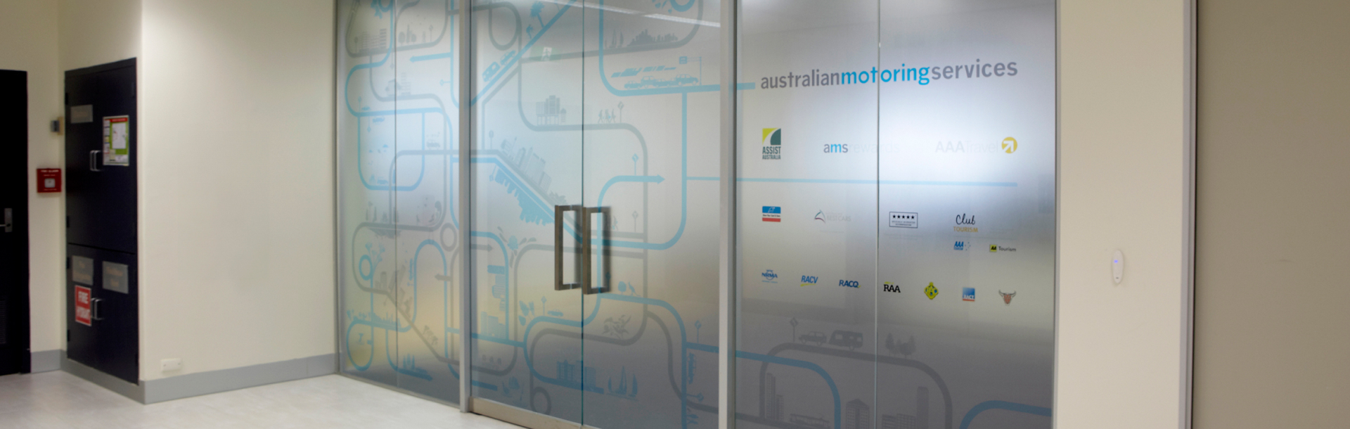 Entrance to Australian Motoring Services office with frosted glass and window decals designed by MOO Marketing & Graphic Design's branding studio in Melbourne